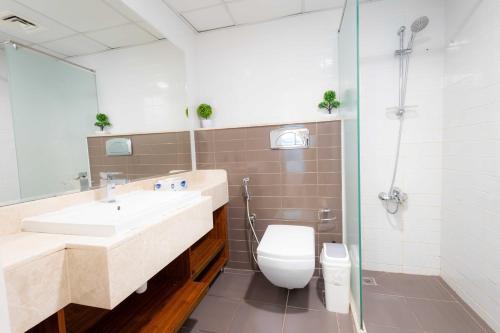 a bathroom with a sink and a toilet and a shower at Modern 1BR with Beach and Pool in Al Marjan Island in Ras al Khaimah