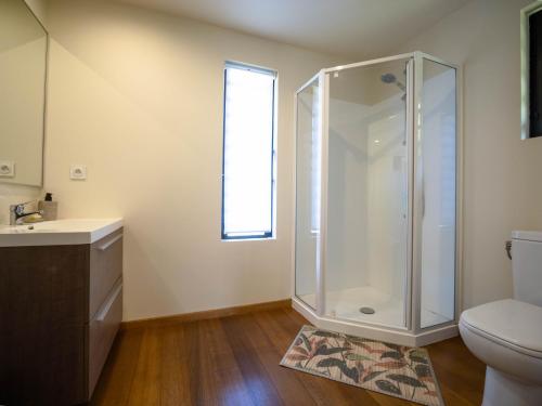a bathroom with a shower and a toilet and a window at Gîte Les Escales La Marina in Bouloupari