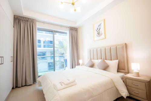 a bedroom with a large white bed and a window at Modern 1BR with Beach and Pool in Al Marjan Island in Ras al Khaimah