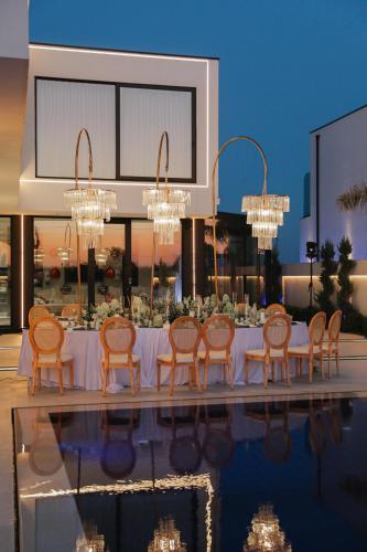 a dining table with chairs and chandeliers at Infinity Villa in Rrushkull