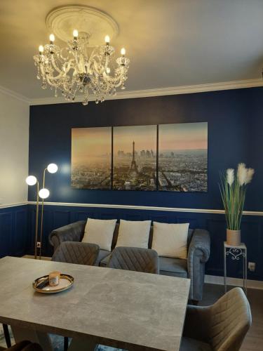 ein Esszimmer mit einem Tisch und einem Kronleuchter in der Unterkunft Villa Napoleon in Les Lilas