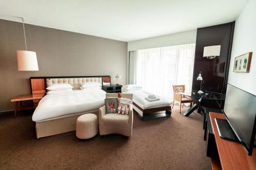 a bedroom with a large bed and a television at Grand Hyatt Berlin in Berlin