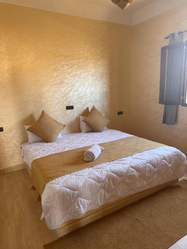 a bedroom with a large bed with white sheets at Dar Amrad in Hassilabied
