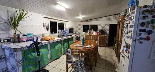 a kitchen with a refrigerator and a table in it at Tiapaa Village in Maupiti