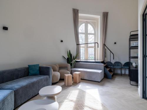 a living room with a couch and a table at Renovated luxury water tower within walking distance of the beach boulevard in Vlissingen