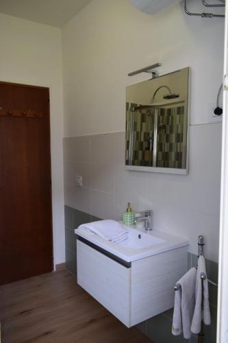 a white bathroom with a sink and a mirror at Casa Il Grande Pino in Tirano
