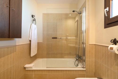 een badkamer met douche en ligbad bij Los Albatros by Ĥ - Playa de los Haraganes HAHB30P190 in Isla Canela