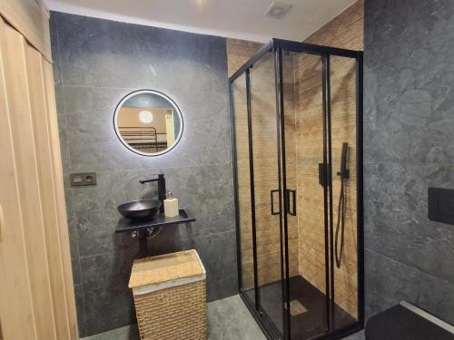 a bathroom with a shower with a sink and a mirror at Plaza Andalucía Edificio Dornajo in Monachil
