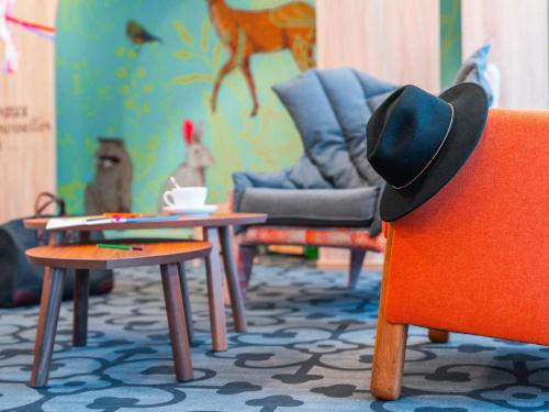 a room with a cowboy hat sitting on a chair at ibis Styles Carcassonne La Cité in Carcassonne