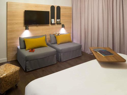 a living room with a couch and a table at ibis Styles Carcassonne La Cité in Carcassonne