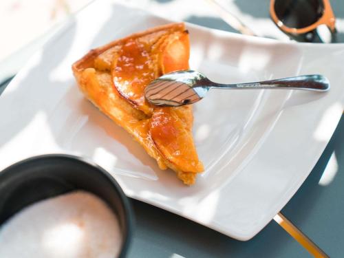 a piece of food on a white plate with a fork at ibis Styles Carcassonne La Cité in Carcassonne