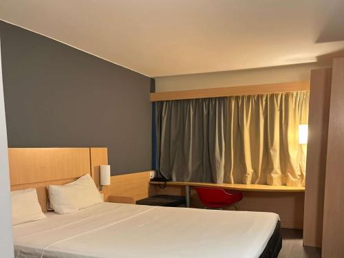 カタランにあるibis Catalaoのベッドが2つと窓があるホテルの部屋