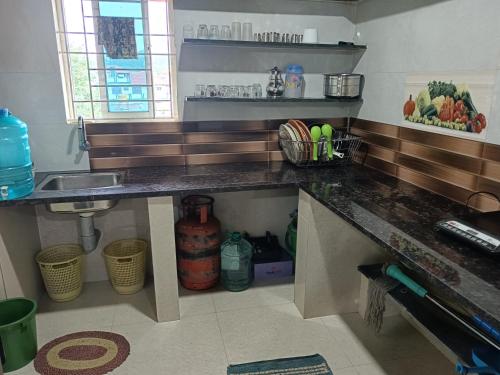 a kitchen with a counter top and a sink at Fortune Holiday cottage in Madikeri