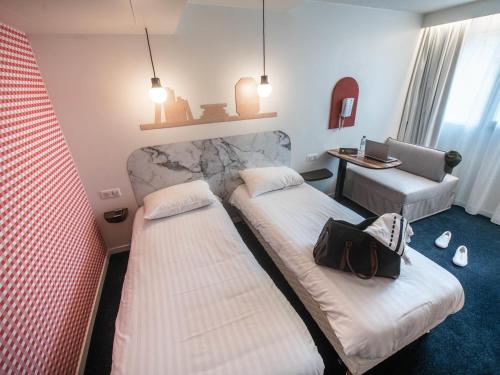 a hotel room with two beds and a desk at Hôtel ibis Styles Vichy Centre in Vichy