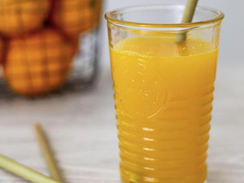 a glass of orange juice with a straw at Hôtel ibis Styles Vichy Centre in Vichy