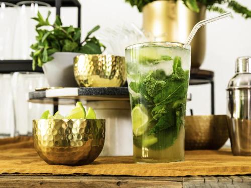 a drink with mint in a glass on a table at Hôtel ibis Styles Vichy Centre in Vichy