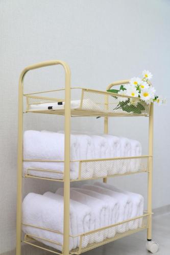 a towel rack with towels and flowers on it at Bitdamjip Near Hwaseong Fortress and Suwon Station in Suwon
