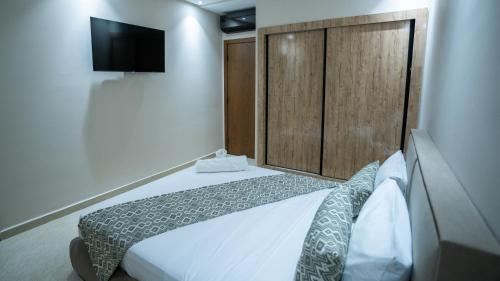a bedroom with a bed and a tv on the wall at Appart Hôtel Golden Sky Home Café Restaurant & Spa in Beni Mellal