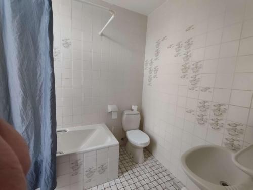 a bathroom with a tub and a toilet and a sink at New City Hotel Scheveningen in Scheveningen