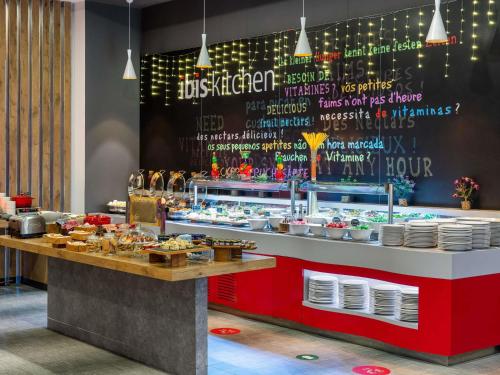 a restaurant with a counter with food on it at Ibis Istanbul Tuzla Hotel in Tuzla