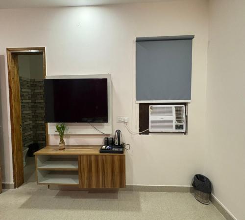 a room with a television and a desk with a telephone at Radiant Blu Hotel in Noida