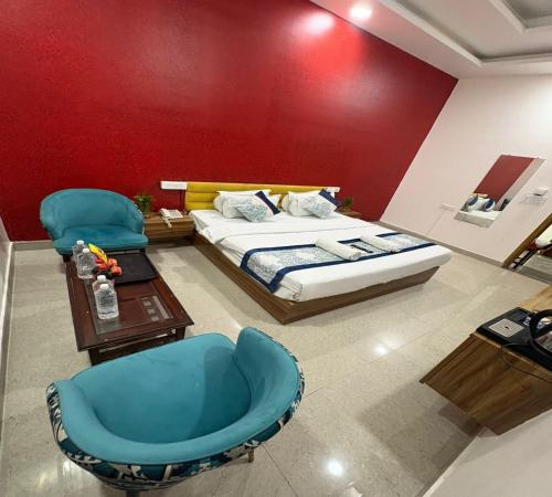 a bedroom with a bed and a blue chair at Radiant Blu Hotel in Noida