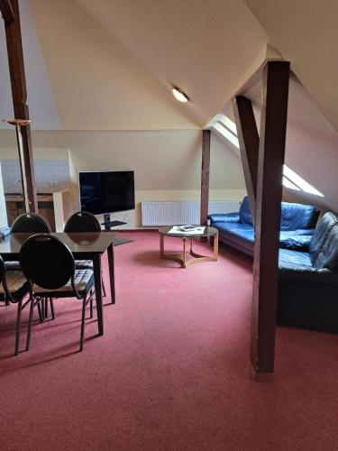 a living room with a couch and a table and chairs at Hotel Rosengarten in Bad Salzuflen