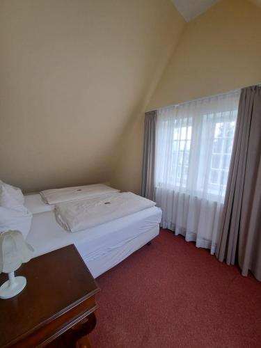 a hotel room with a bed and a window at Hotel Rosengarten in Bad Salzuflen