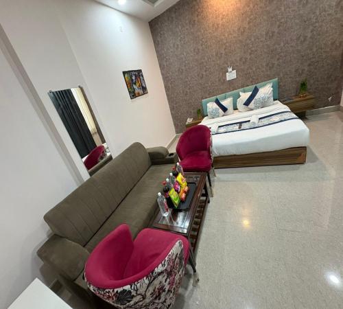 a living room with a couch and a bed at Radiant Blu Hotel in Noida