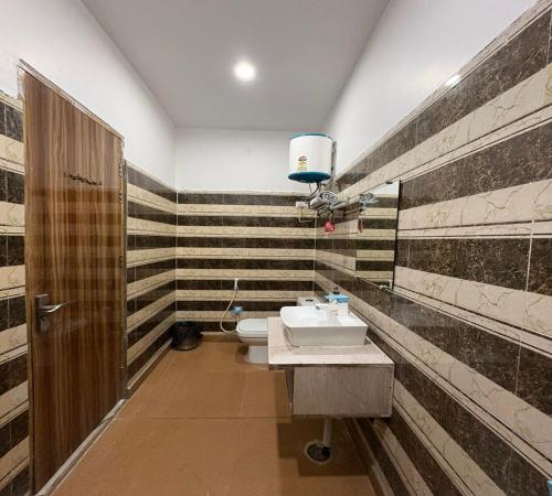 a bathroom with a sink and a toilet at Radiant Blu Hotel in Noida