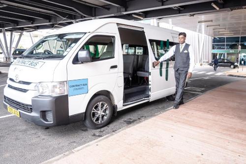 a man is standing outside of a white van at Holiday Inn Mauritius Mon Trésor by IHG in Blue Bay