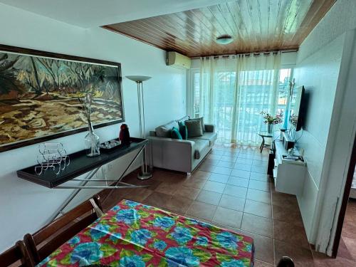 ein Wohnzimmer mit einer Couch und einem Gemälde an der Wand in der Unterkunft Flat 601 Condominio Villa Hípica - Gravatá, PE in Gravatá