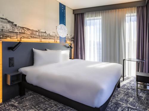 a large white bed in a hotel room at ibis Styles Basel City in Basel