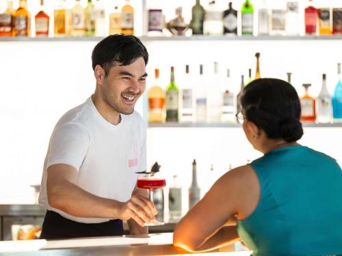 a man and a woman standing at a bar holding a drink at ibis Styles Basel City in Basel