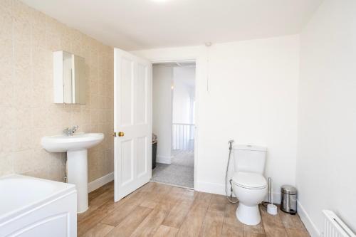 a bathroom with a toilet and a sink at Gloucester Street Nest - 3BR Flat for 6 Guests in Stroud