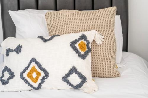 a group of pillows sitting on a bed at Gloucester Street Nest - 3BR Flat for 6 Guests in Stroud