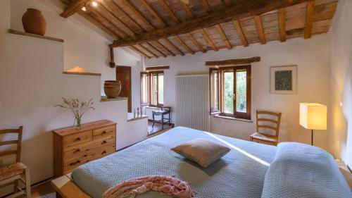 a bedroom with a bed and a dresser and windows at Ca Lucciola 12 by Marche Holiday Villas in Montemaggiore al Metauro