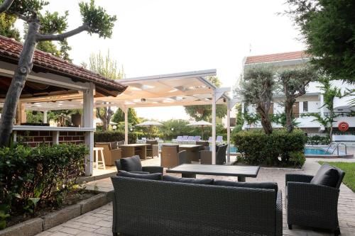 a patio with a table and chairs under a pavilion at Terinikos Sunny Garden Hotel & Junior Suites New Renovation 2025 in Ialyssos