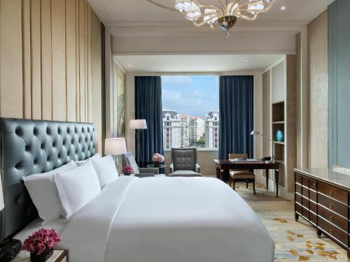 a bedroom with a large white bed and a desk at Sofitel Shanghai Hongqiao in Shanghai