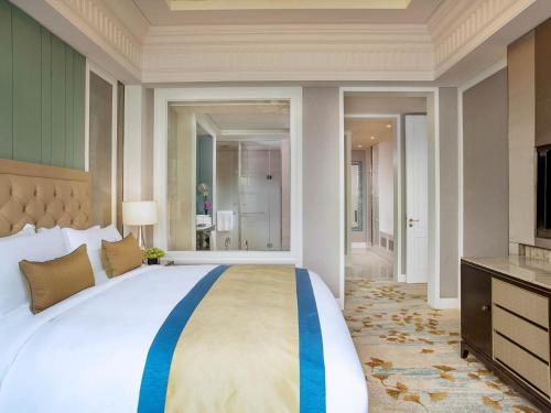 a bedroom with a large bed and a television at Sofitel Shanghai Hongqiao in Shanghai