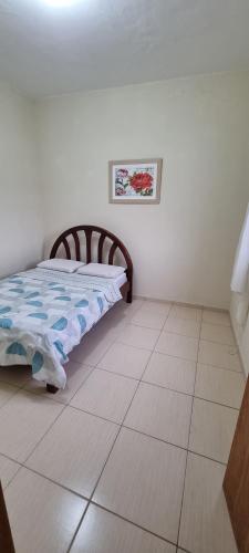 a bedroom with a bed and a tiled floor at Casa com ampla área de lazer há 10 minutos do Santuário de Aparecida in Guaratinguetá