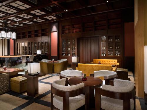 a lobby with chairs and tables and a bar at Sofitel Shanghai Hongqiao in Shanghai