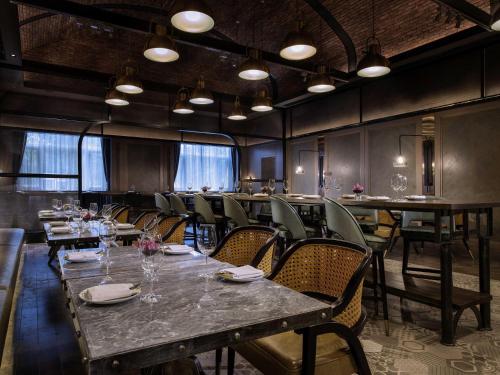a dining room with tables and chairs in a restaurant at Sofitel Shanghai Hongqiao in Shanghai