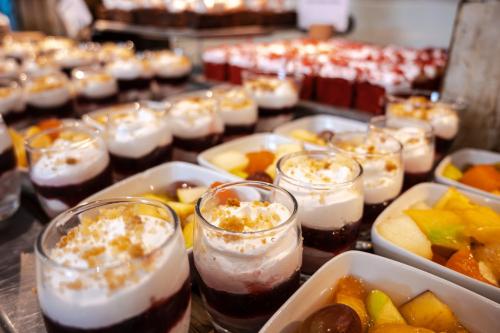 a table topped with glasses of desserts and bowls of fruit at Holiday Inn Mauritius Mon Trésor by IHG in Blue Bay