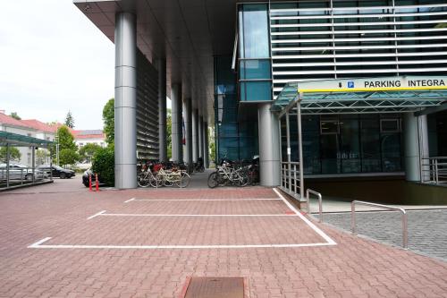 a large building with bikes parked in a parking lot at Apart-hotel Integra in Banja Luka