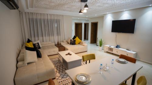 a living room with a couch and a table at Appart Hôtel Golden Sky Home Café Restaurant & Spa in Beni Mellal