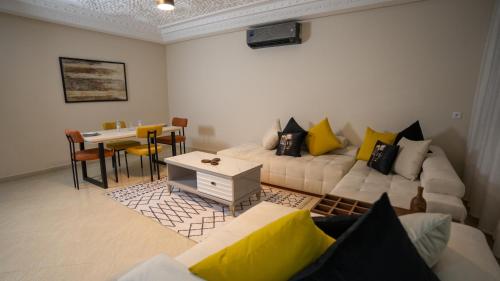 a living room with a white couch and a table at Appart Hôtel Golden Sky Home Café Restaurant & Spa in Beni Mellal