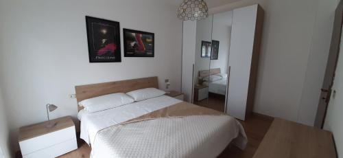 a bedroom with a white bed and a mirror at Casa Il Grande Pino in Tirano