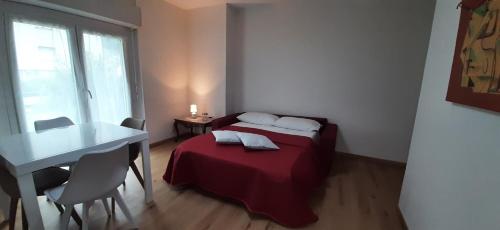 a bedroom with a bed and a table and a window at Casa Il Grande Pino in Tirano