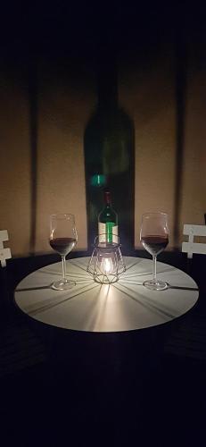 a table with two glasses and a bottle of wine at Casa Il Grande Pino in Tirano